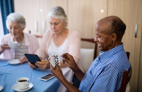 A man focused on his deck of cards, showcasing how Medicare Advantage can help seniors cope with stress.